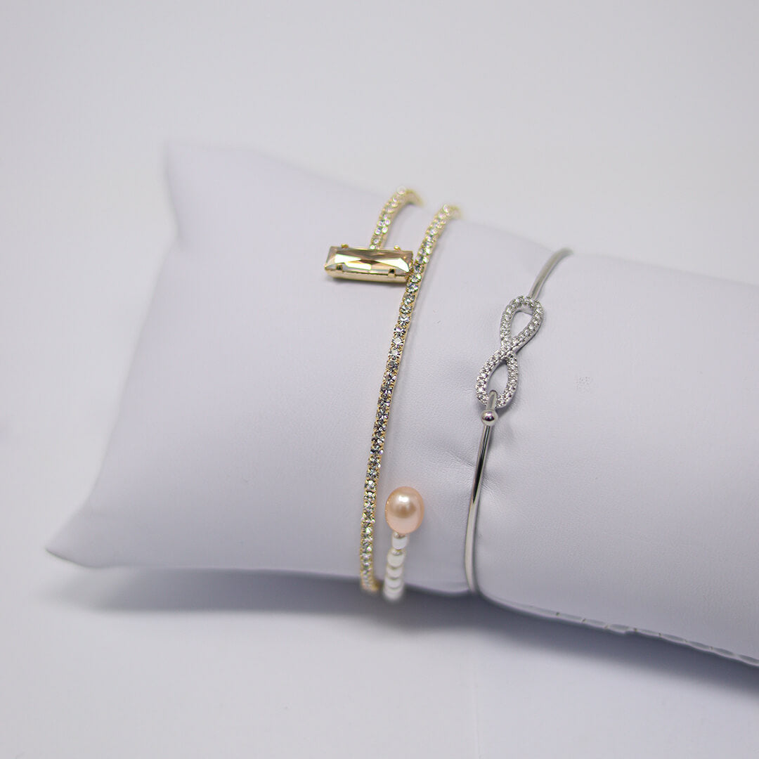 Gold-plated Pearl Bangle shown with another bracelet on a display- BELLE DE SOIREE Pearl Bangle Riviera