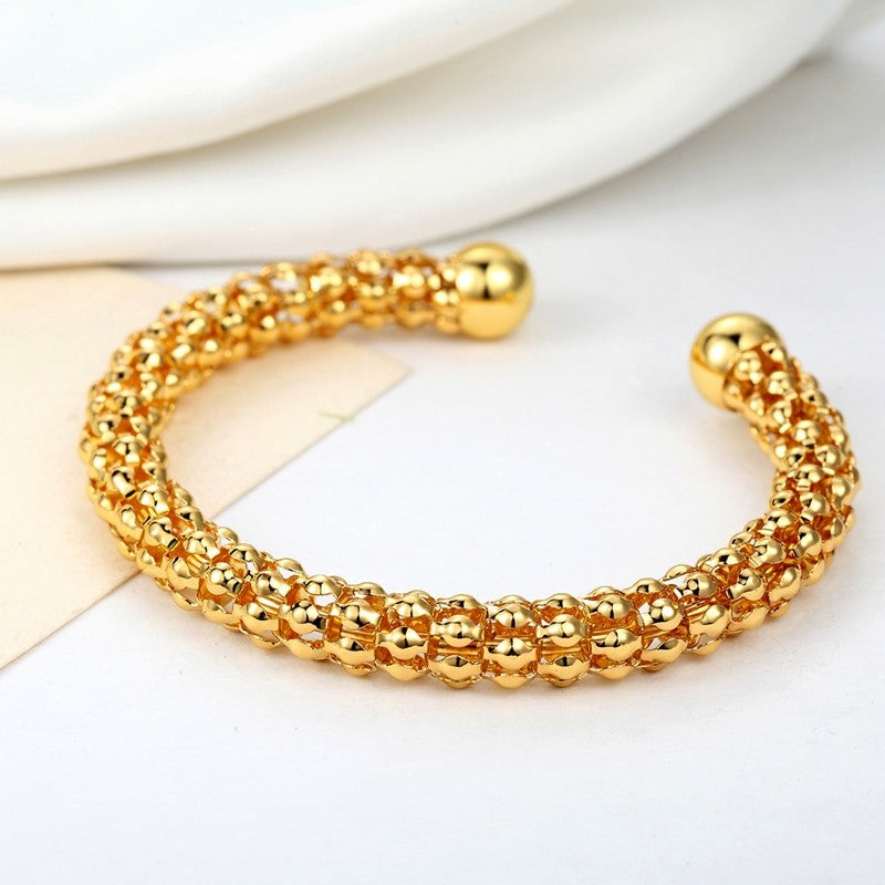 Gold beaded bracelet on a white surface-BELLEDESOIREE
