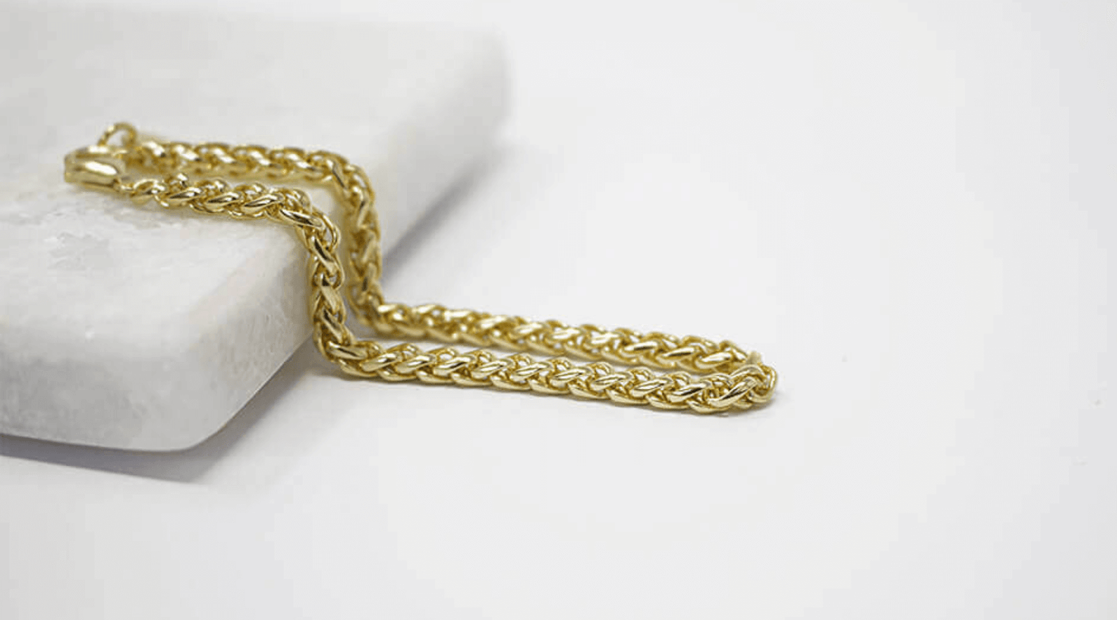 Gold chain on a white surface