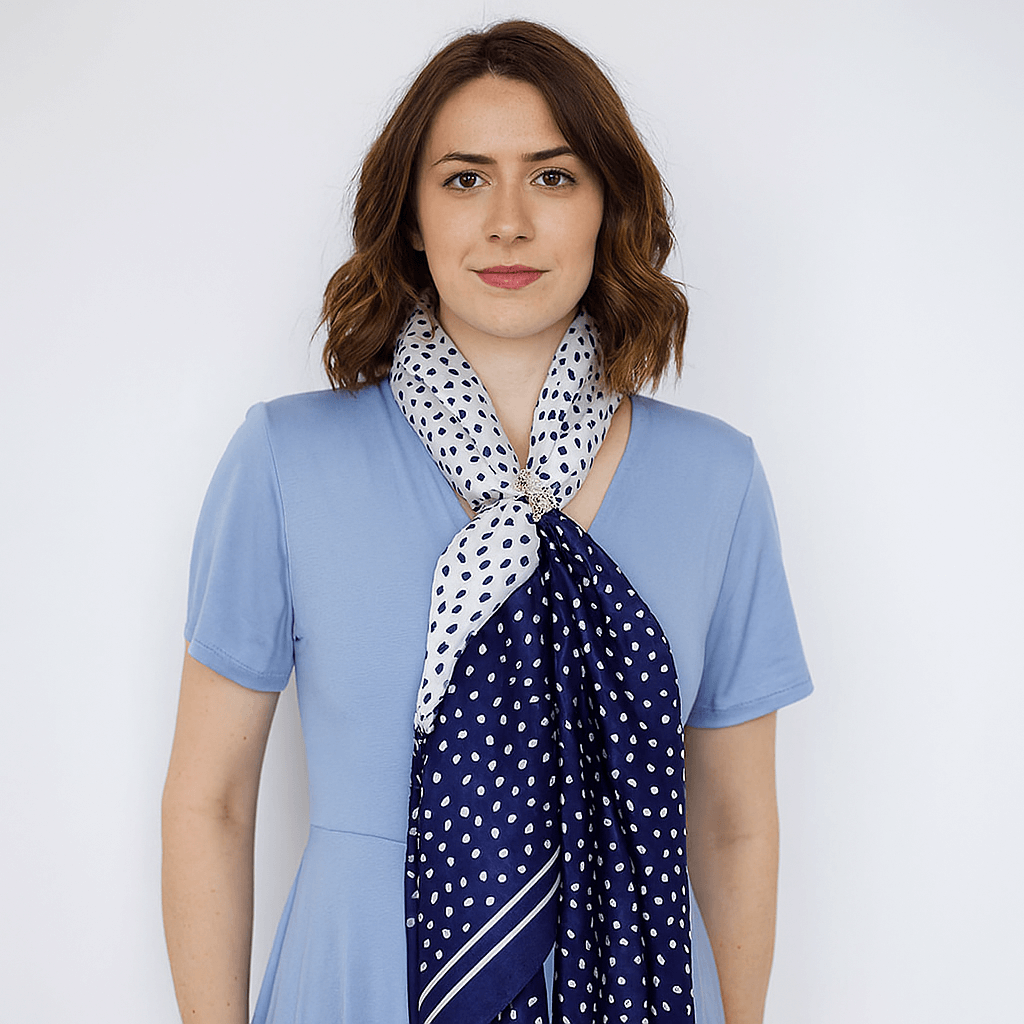 Woman wearing a blue dress with a polka dot scarf against a white background