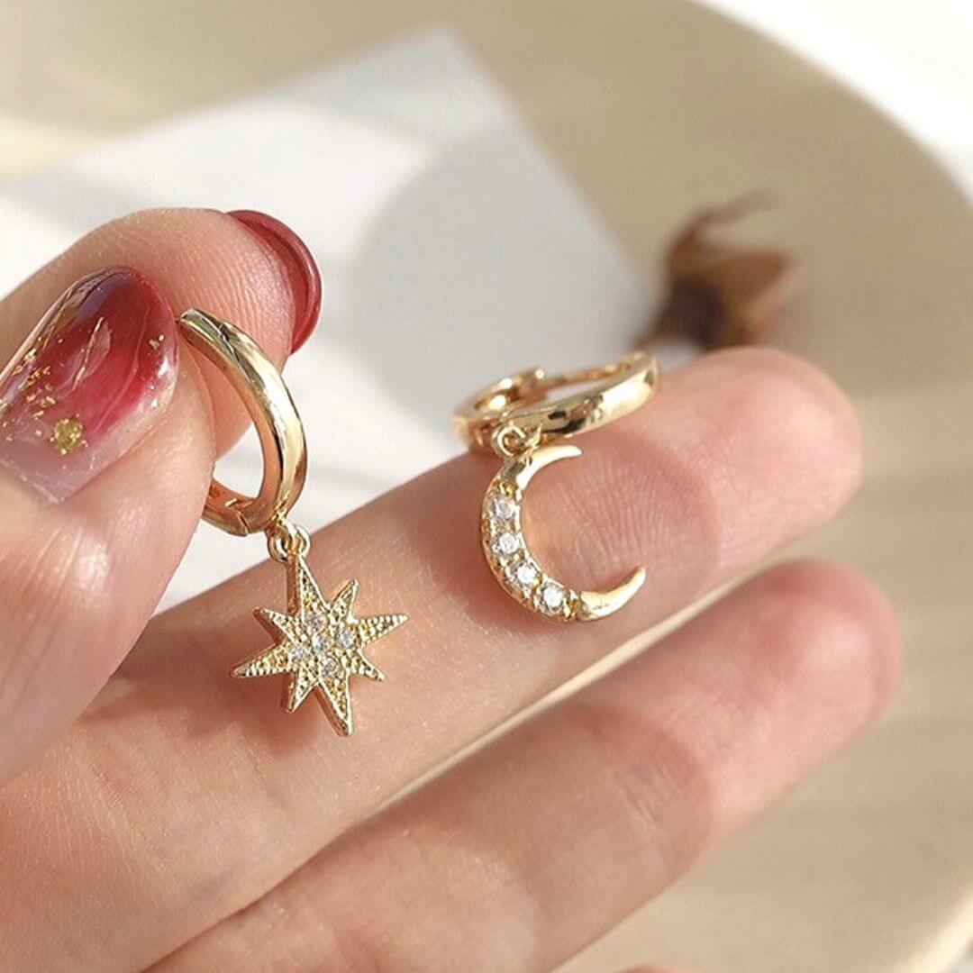 Asymmetric Make Me Dream Earrings carried by a model's hand- BELLEDESOREE  silver & gold dangle earrings