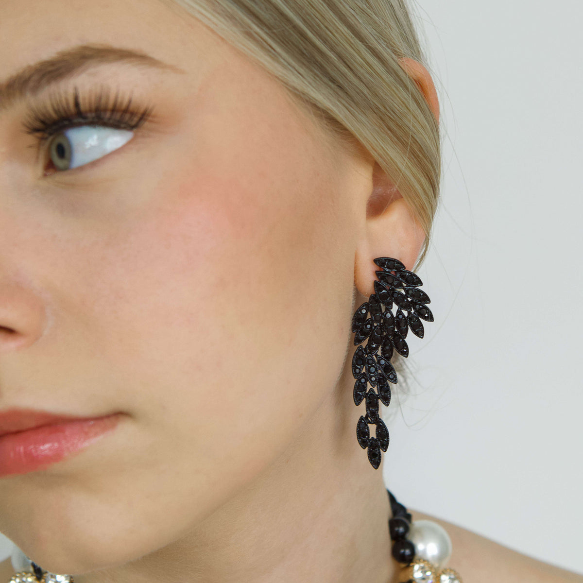 Black medium-sized Rhinestone Earrings worn by a woman with blond hair-Belle de Soiree medium-sized black rhinestone earrings