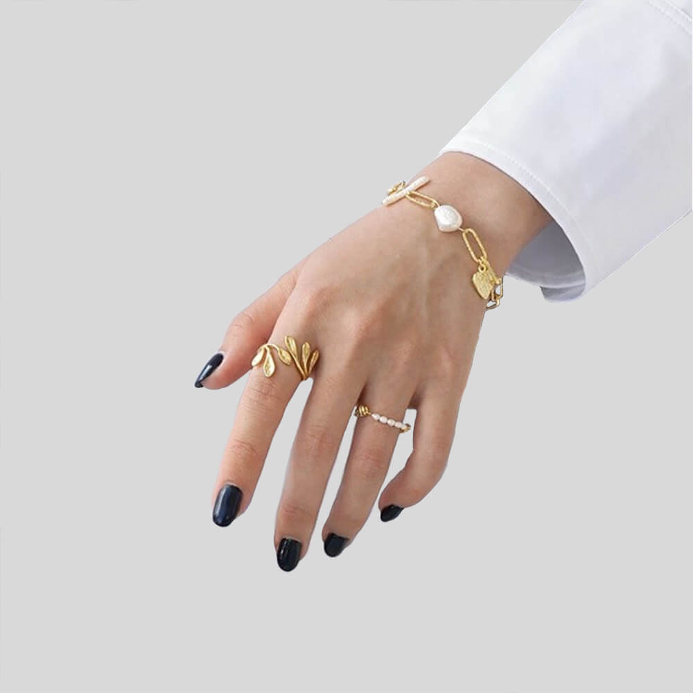 Pearl Heart Sterling Shimmering Charm Bracelet shown on the wrist of a model- BELLEDESOIREE shimmering charm gold pearl bracelet