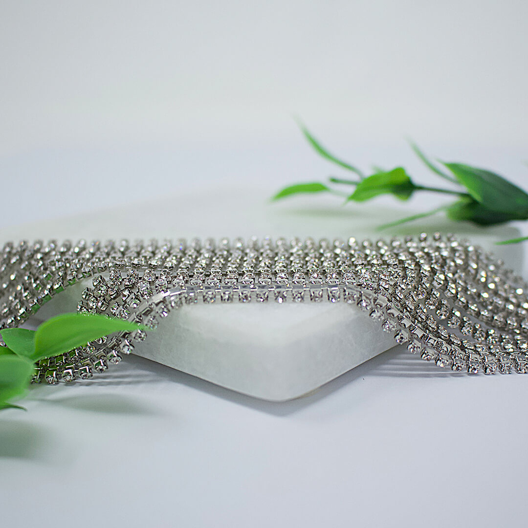 Rhinestone Crystal Choker Caroline shown  beautifully on a white display surrounded by green leaves -belledesoiree.com Rhinestone Crystal Choker Caroline