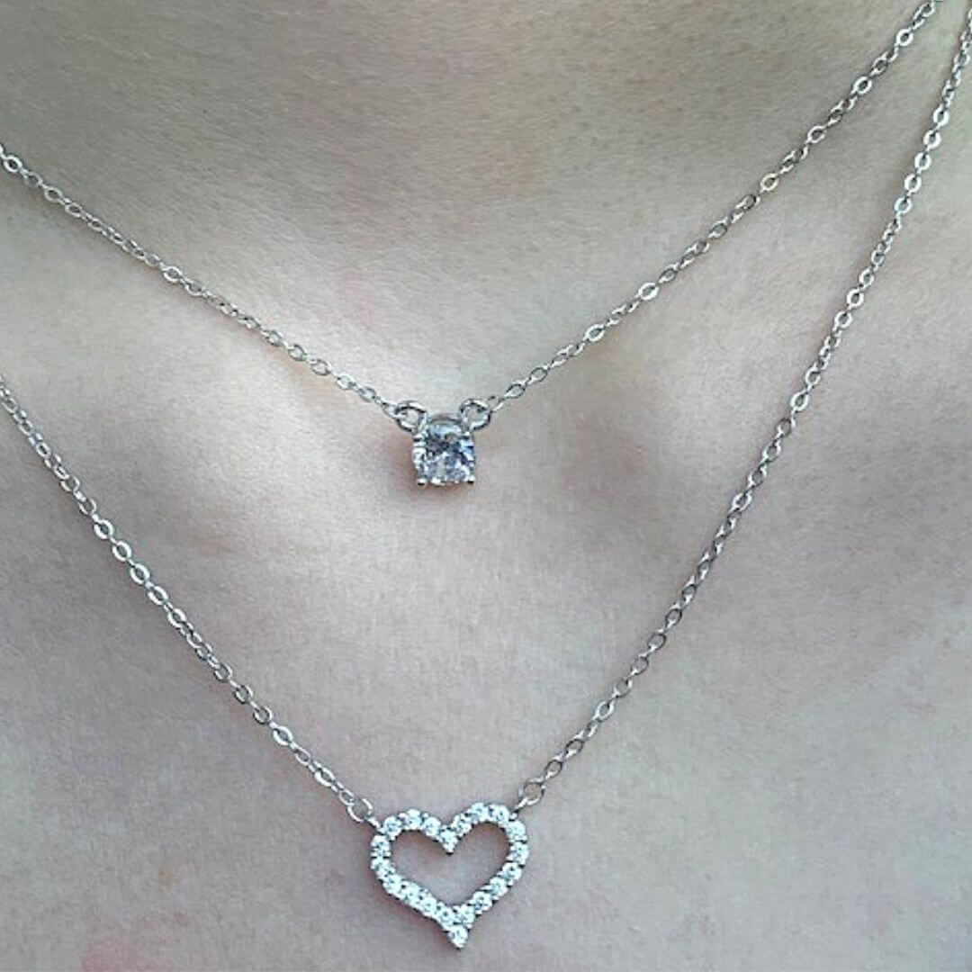 A sterling silver heart-shaped necklace with a chain layering and a sparkling stone on the top layer- BELLE DE SOIREE Sterling Silver Heart Necklace